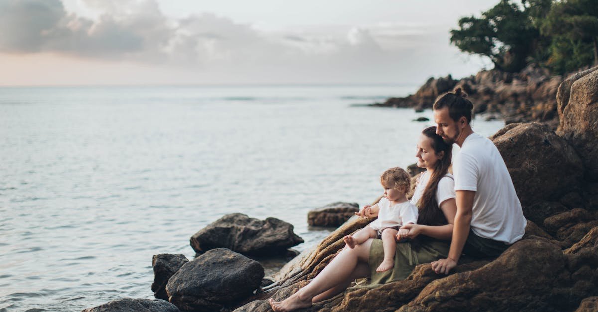 A serene family moment by the seaside, capturing love and relaxation at sunset.