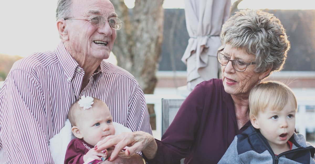 Grandparents spending joyful moments with their grandchildren in an outdoor setting, captured candidly.